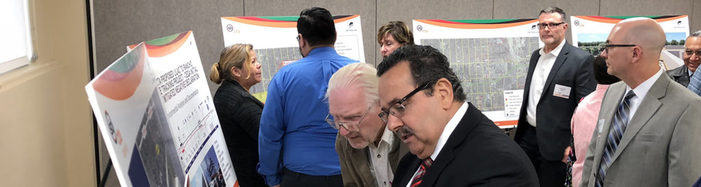 People reading Metrolink San Bernardino Line Double Track Project (Lilac to Rancho) banners